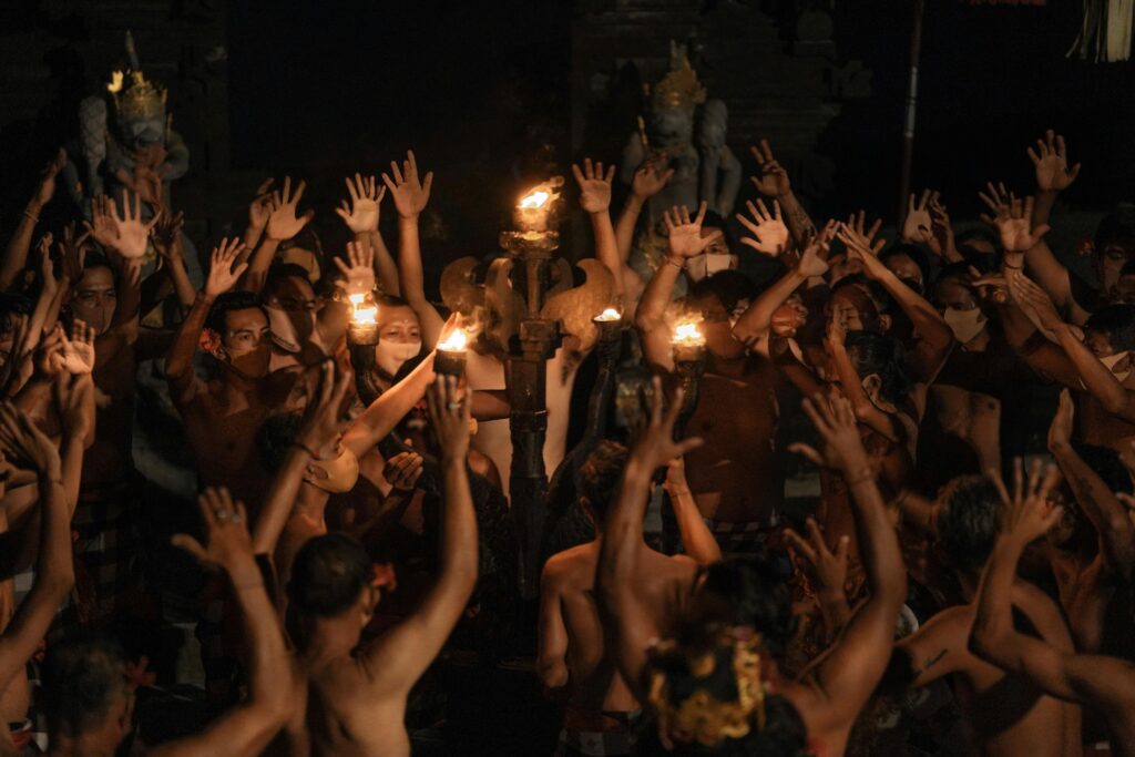 Authentic Balinese Kecak dance featuring men with raised arms and torches in Indonesia.