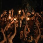 Authentic Balinese Kecak dance featuring men with raised arms and torches in Indonesia.